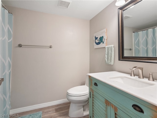 bathroom with vanity, hardwood / wood-style flooring, and toilet