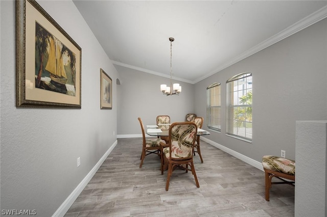 dining space featuring lofted ceiling, light hardwood / wood-style flooring, ornamental molding, and a notable chandelier