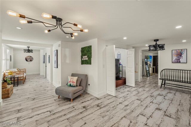 interior space with washer / clothes dryer, a notable chandelier, and light hardwood / wood-style flooring