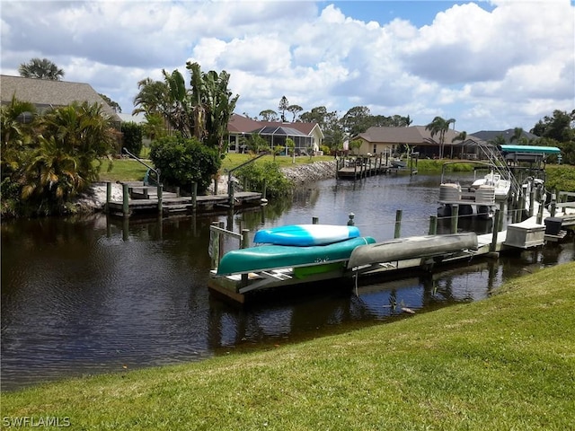 view of dock featuring a water view, boat lift, a residential view, and a yard