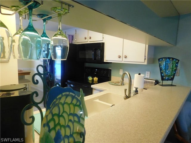 kitchen with black appliances, white cabinets, a sink, and light countertops