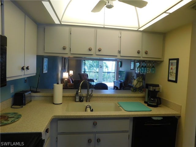 kitchen featuring ceiling fan, white cabinets, sink, black dishwasher, and stove