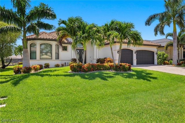 mediterranean / spanish house featuring a garage and a front lawn