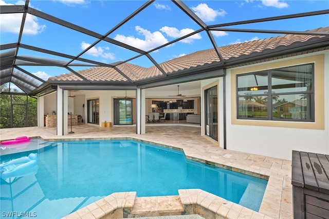 view of pool featuring ceiling fan, a patio area, and glass enclosure