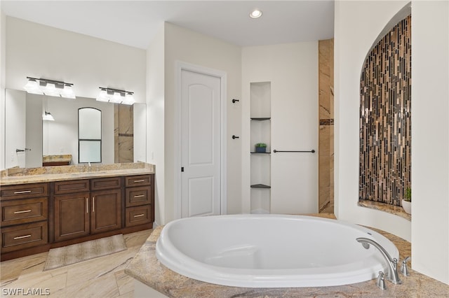 bathroom with vanity and tiled bath