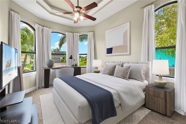 bedroom featuring ceiling fan and a tray ceiling