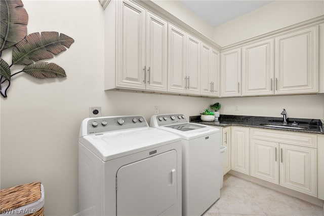 washroom with separate washer and dryer, sink, light tile patterned floors, and cabinets