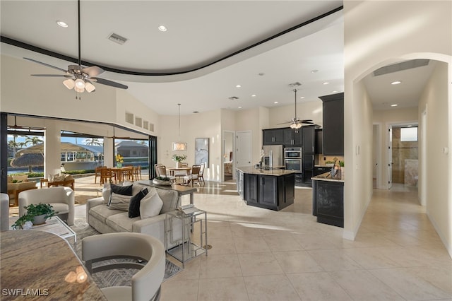 tiled living room with a towering ceiling and ceiling fan