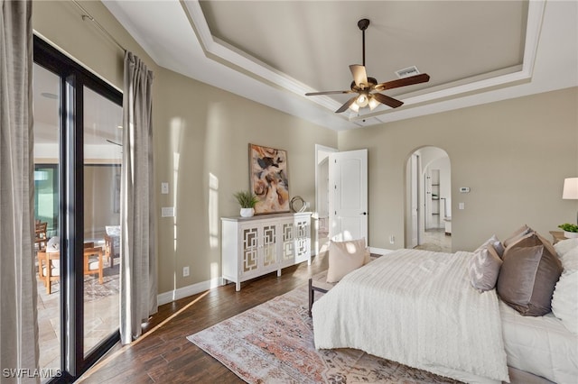 bedroom featuring dark hardwood / wood-style flooring and a tray ceiling