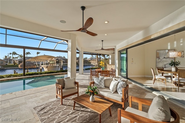 interior space featuring a patio, a lanai, an outdoor hangout area, ceiling fan, and a water view