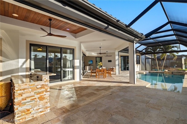 exterior space featuring a patio, exterior bar, ceiling fan, and glass enclosure