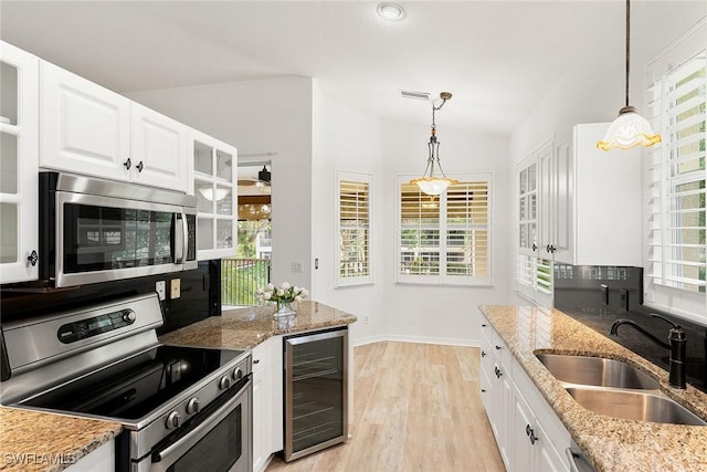 kitchen with visible vents, a sink, white cabinetry, wine cooler, and appliances with stainless steel finishes
