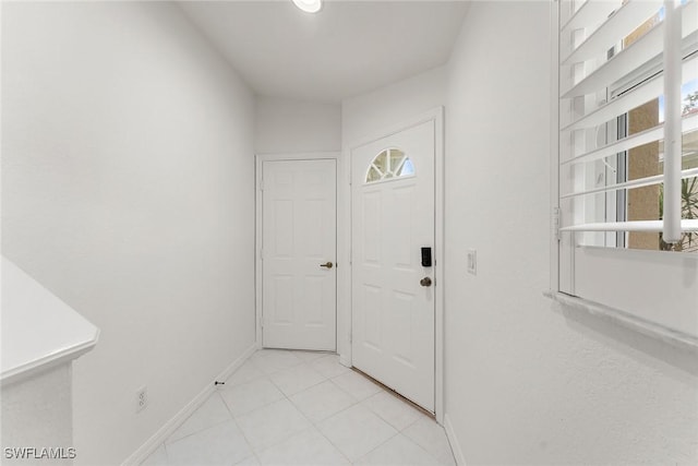 entrance foyer with light tile patterned flooring and baseboards