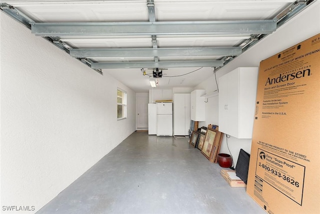 garage featuring a garage door opener and freestanding refrigerator