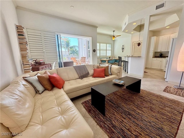 living room with ceiling fan, light tile patterned floors, and ornamental molding