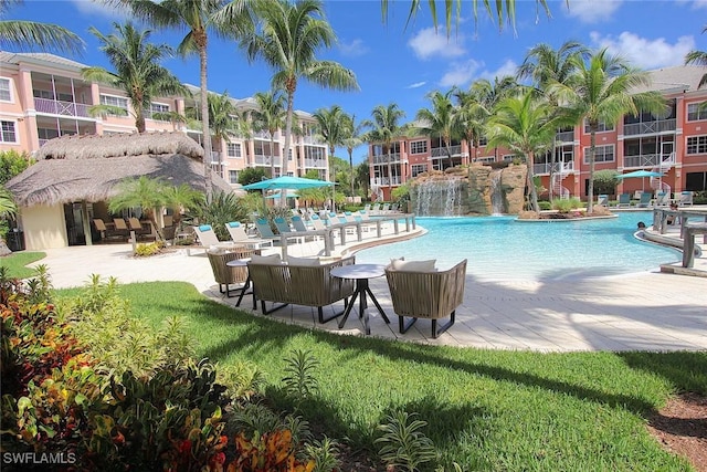 view of pool featuring pool water feature and a lawn