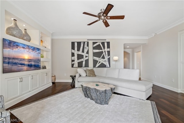 living room with built in features, dark hardwood / wood-style flooring, ornamental molding, and ceiling fan