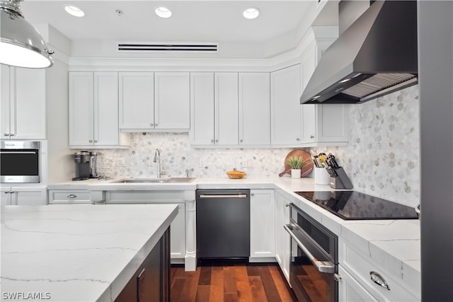 kitchen with white cabinetry, sink, stainless steel oven, and wall chimney exhaust hood