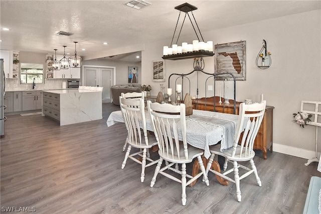 dining area featuring dark wood-type flooring and a textured ceiling