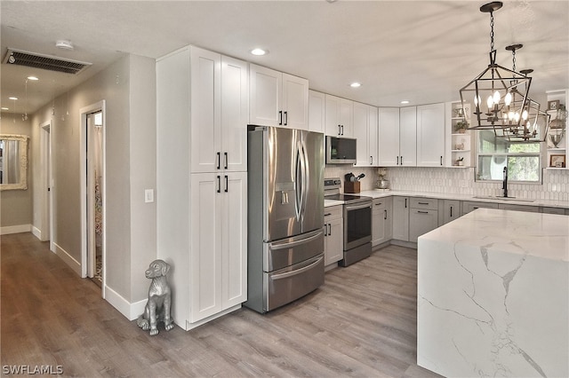 kitchen featuring stainless steel appliances, backsplash, hardwood / wood-style floors, and sink