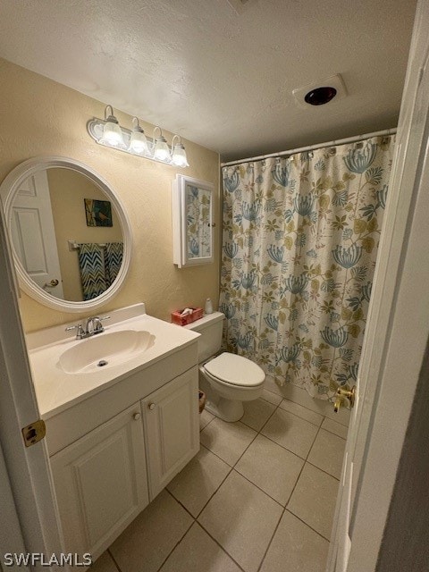 bathroom with tile patterned flooring, vanity, a textured ceiling, and toilet