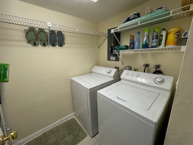 laundry area with separate washer and dryer and light tile patterned floors