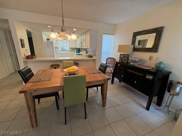 dining room with light tile patterned floors and an inviting chandelier