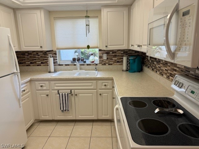 kitchen featuring white cabinets, light tile patterned floors, white appliances, and sink