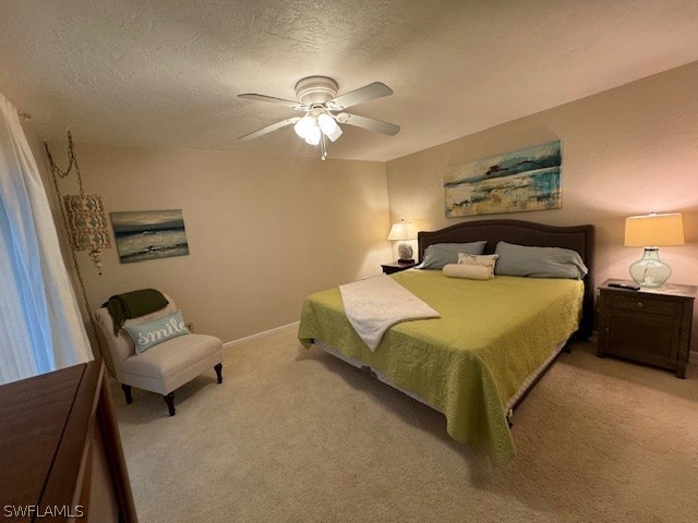 carpeted bedroom featuring a textured ceiling and ceiling fan