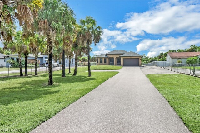 view of front of home with a garage and a front lawn