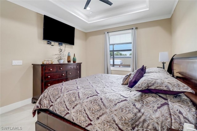 tiled bedroom featuring a raised ceiling and ceiling fan