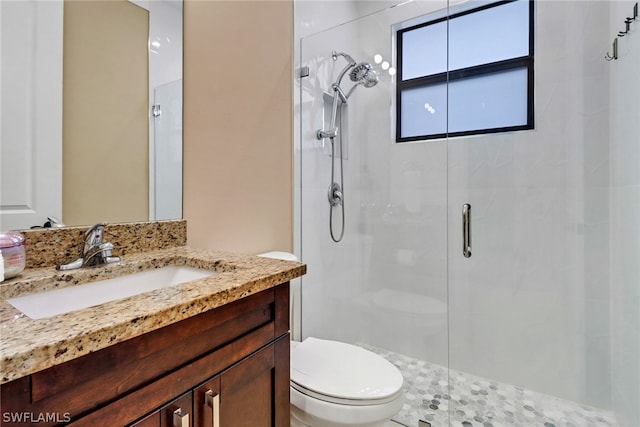 bathroom featuring vanity, toilet, and walk in shower