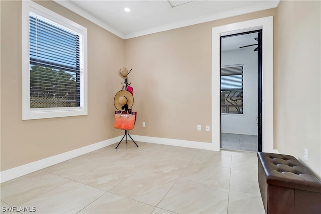 tiled empty room featuring crown molding