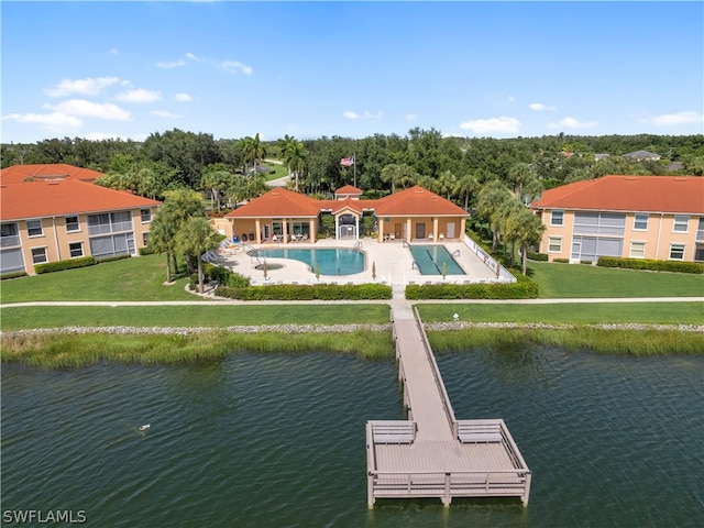 exterior space featuring a water view, a community pool, and a yard