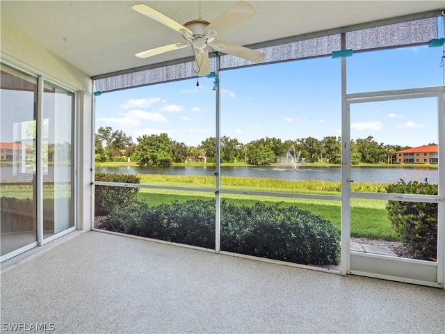 unfurnished sunroom with a water view and ceiling fan