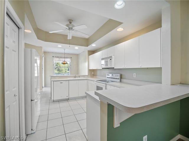 kitchen with white appliances, kitchen peninsula, decorative light fixtures, white cabinetry, and ceiling fan