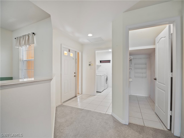 hallway featuring light carpet and washer and clothes dryer