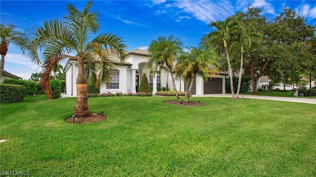 view of front of home featuring a garage, concrete driveway, a front yard, and stucco siding