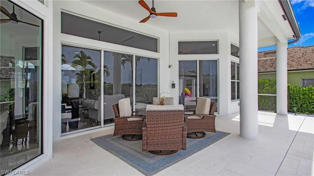 view of patio featuring outdoor dining area, ceiling fan, and fence