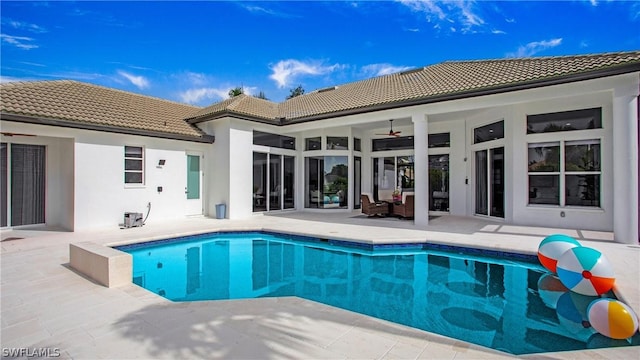 outdoor pool with a patio area and a ceiling fan