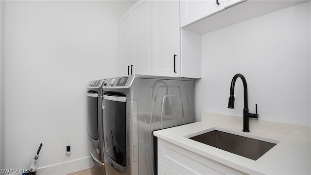 washroom featuring sink, cabinets, and washing machine and clothes dryer