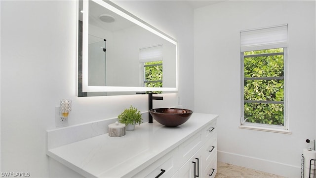 bathroom with plenty of natural light, vanity, and baseboards