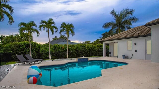 pool at dusk with a patio