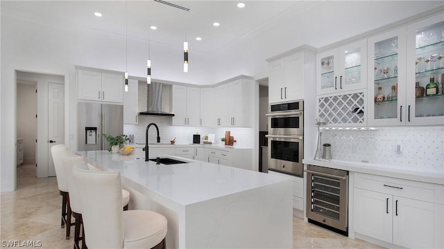 kitchen featuring appliances with stainless steel finishes, beverage cooler, pendant lighting, and white cabinets