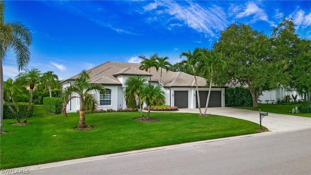 view of front of property featuring a tile roof, stucco siding, an attached garage, driveway, and a front lawn