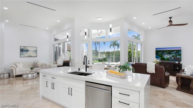 kitchen with sink, white cabinetry, ceiling fan, stainless steel dishwasher, and a center island with sink