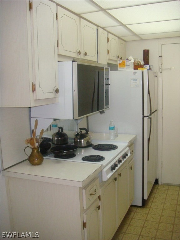 kitchen featuring light tile patterned flooring and white cabinets