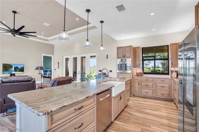 kitchen featuring a wealth of natural light, sink, a kitchen island with sink, and stainless steel appliances