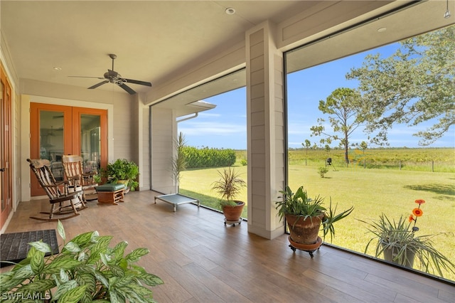 sunroom featuring a rural view and ceiling fan