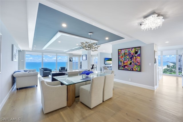 dining room with floor to ceiling windows, light wood-type flooring, and an inviting chandelier